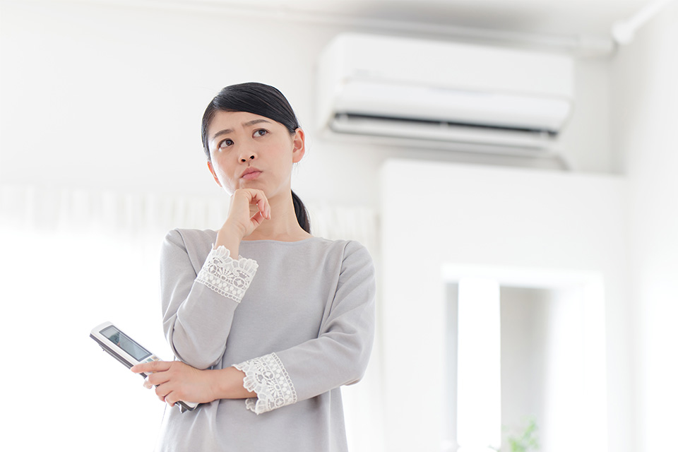 暖房が途中で止まる原因を考える女性