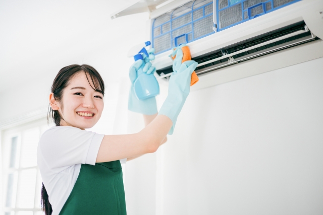 エアコンフィルターの掃除をする女性
